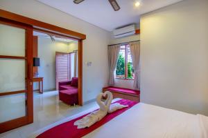 un dormitorio con una cama con una decoración de cisne en Asoka Hotel & Suite, en Sanur