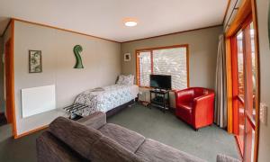 un soggiorno con divano e letto di The Whistling Frog Resort a Chaslands