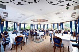 un comedor con mesas, sillas y ventanas en Shangrila Boutique Hotel, en Wujie