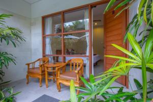 a room with two chairs and a table and a window at Asoka Hotel & Suite in Sanur