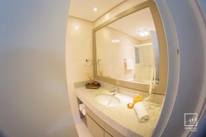 a bathroom with a sink and a large mirror at Apto Fofo in Gramado +49 photos