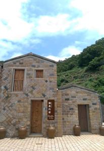 un edificio in pietra con due porte e un cartello sopra di Chairman's Villa a Beigan