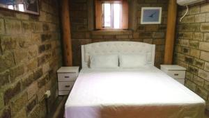 北竿鄉的住宿－議長的家 Villa  ，一间砖墙内白色床的卧室