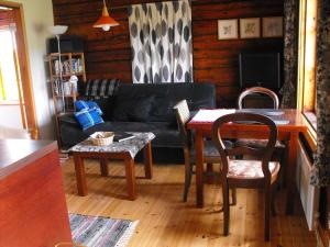 a living room with a table and a couch at Rukkilille Holiday Home in Pärsama