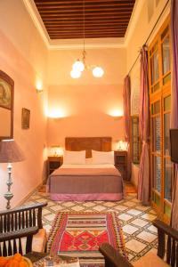 a bedroom with a bed and a couch in a room at Dar El Kébira in Rabat