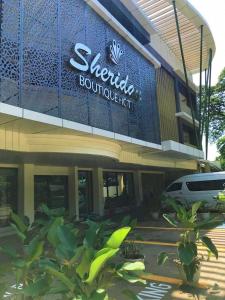 a building with a sign on the side of it at Sheridan Boutique Hotel in Puerto Princesa City