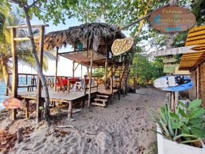 um restaurante na praia com cadeiras e mesas em Cabarete Maravilla Eco Lodge Boutique Beach Surf, Kite, Yoga em Cabarete