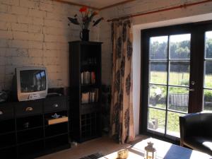 a living room with a tv and a window at Rukkilille Holiday Home in Pärsama
