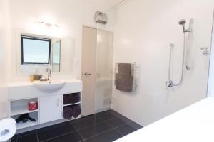 a bathroom with a sink and a shower at Woodbank Park Cottages in Hanmer Springs