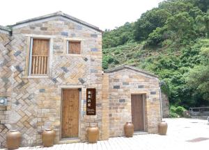 - un bâtiment en pierre avec deux portes et un panneau dans l'établissement Chairman's Villa, à Beigan