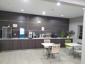 a kitchen with tables and chairs and a counter at Haven Inn & Suites willowbrook in Houston