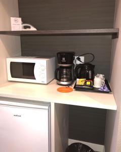 a kitchen with a microwave and a cupboard at Hotel Kauppi in Tampere