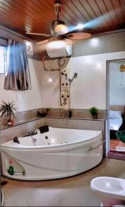 een groot wit bad in een badkamer met een plafond bij Taiping Vacation Home in Taiping