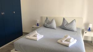 łóżko z poduszkami i ręcznikami na górze w obiekcie Le Sabbie Nere w mieście Vulcano