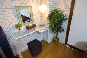 a bathroom with a mirror and a stool and plants at Comfort CUBE PHOENIX Beppu (やよいビル) in Beppu