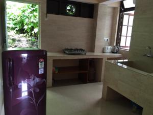a kitchen with a refrigerator in the middle of a room at Vamoose Pegs in Gangtok