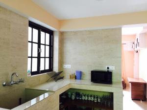 a kitchen with a counter with bottles on it at Vamoose Pegs in Gangtok