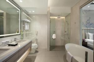 un bagno con vasca, WC e lavandino di Mason Pine Hotel Bandung a Padalarang