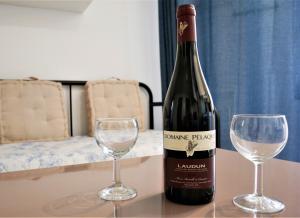 una bottiglia di vino e due bicchieri su un tavolo di le Travertin ad Avignone
