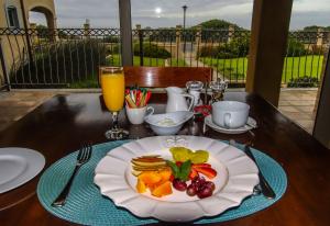 a table with a plate of food and a glass of orange juice at On The Cliff Guest House in Hermanus