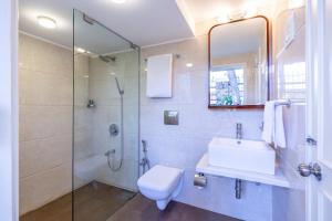 a bathroom with a shower and a toilet and a sink at amã Stays & Trails, Beach House Madh Island in Mumbai