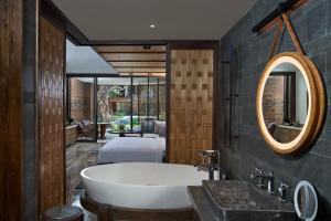 a bathroom with a bath tub and a sink at Andaz Bali, By Hyatt in Sanur