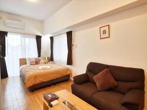 sala de estar con sofá y cama en M´s Stay Okinawa, en Chatan