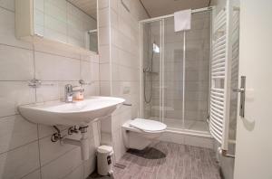 a bathroom with a sink and a toilet and a shower at Miraflor Sonja by Arosa Holiday in Arosa