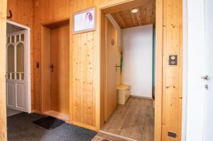 a room with wooden walls and a hallway with two doors at Miraflor Sonja by Arosa Holiday in Arosa