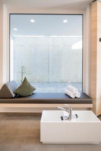 ein Badezimmer mit einem Fensterplatz, einem Waschbecken und einer Badewanne in der Unterkunft Appartementhotel Röhrenbach in Immenstaad am Bodensee