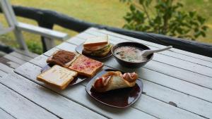 una mesa con dos platos de sándwiches y un tazón de sopa en Baan Pong Tara, en Suan Phueng