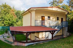 a small house with a large red roof at Apartmány Nad Parkem in Broumov