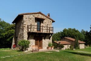 an old stone house with a bench in front of it at Tenuta Le Pianore in Cinigiano