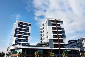 two tall buildings with palm trees in front of them at CABA HOTEL &SPA in İzmir