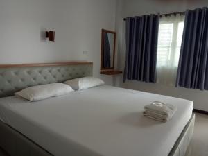 a white bed with two towels on top of it at เคียงเลิงรีสอร์ท in Ban Nong Bua Thong