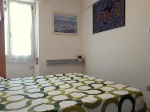 a bedroom with a bed with a green and white blanket at Appartamento Stella in Lido di Pomposa