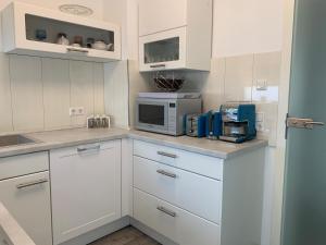 a kitchen with white cabinets and a microwave at Traumferienwohnung in Heilbronn