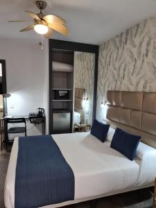a bedroom with a large bed with blue pillows at Bajondillo Beach Cozy Inns in Torremolinos