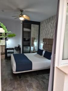 una camera da letto con un grande letto con cuscini blu di Bajondillo Beach Cozy Inns a Torremolinos