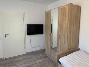 a bedroom with a tv and a wooden cabinet at Traumferienwohnung in Heilbronn
