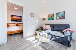 ein Wohnzimmer mit einem Sofa und einem Bett in der Unterkunft Haus Pirola Bensersiel in Bensersiel