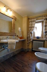 bagno con 2 lavandini e specchio di Hotel Da Compagnoni a Breuil-Cervinia