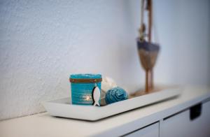 a white shelf with a blue container and ball of yarn at Haus Pirola Bensersiel in Bensersiel
