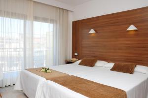 a bedroom with a large bed with a wooden headboard at Prince Park in Benidorm