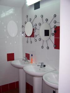 a bathroom with two sinks and two mirrors at Bilbao Akelarre Hostel in Bilbao