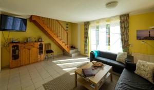 ein Wohnzimmer mit einem Sofa und einem TV in der Unterkunft Ferienhaus-Butterblume in Papenburg