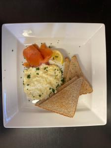 a white plate of food with eggs and crackers at No12 Hotel in North Berwick