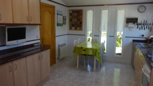eine Küche mit einem grünen Tisch und Stühlen darin in der Unterkunft R88 Casa Alegre in Segur de Calafell