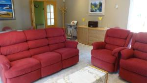 ein Wohnzimmer mit einem roten Sofa und zwei Stühlen in der Unterkunft R88 Casa Alegre in Segur de Calafell