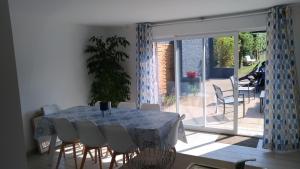 a dining room with a table and chairs and a patio at Au galet bleu in Dieppe